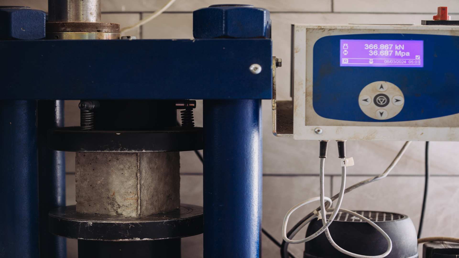 Hydraulic,Press,Performing,Compression,Test,On,Concrete,Sample,In,Material